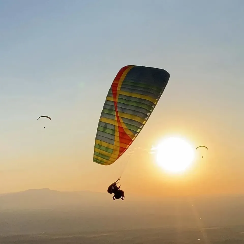 Paraglider flying at sunset